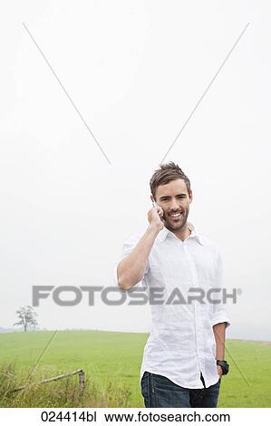 Stock Image - portrait of young man talking on mobile phone. Fotosearch