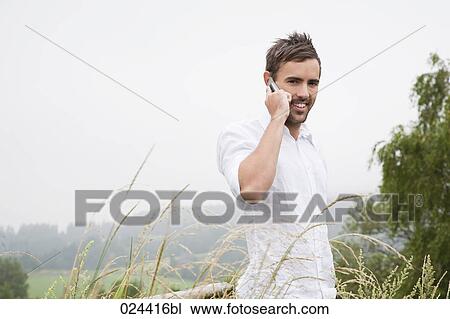 Stock Image - portrait of young man talking on mobile phone. Fotosearch