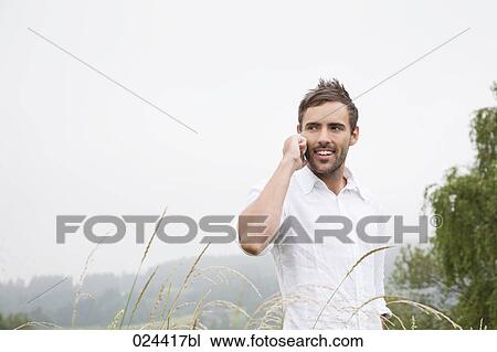 Stock Image - portrait of young man talking on mobile phone. Fotosearch