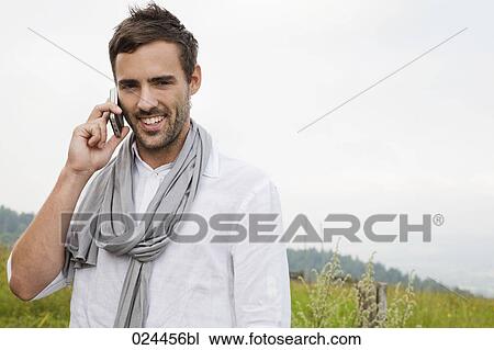 Stock Image - portrait of young man talking on mobile phone. Fotosearch