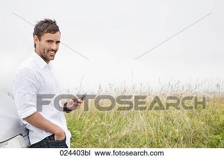 Stock Image - portrait of young man with mobile phone. Fotosearch