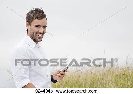 Stock Image - portrait of young man with mobile phone. Fotosearch