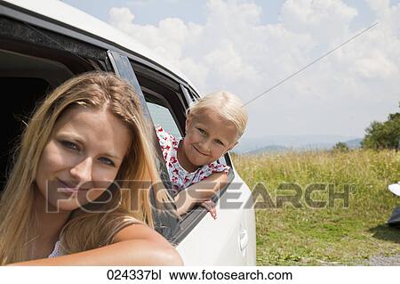 Stock Image - portrait of young woman and daughter looking out of car window. Fotosearch
