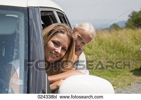 Stock Image - portrait of young woman and daughter looking out of car window. Fotosearch