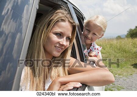 Stock Image - portrait of young woman and daughter looking out of car window. Fotosearch