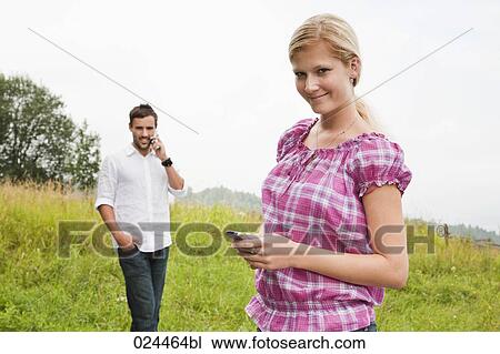 portrait of young woman and man with mobile phones View Large Photo Image Stock Image - portrait of young woman and man with mobile phones. Fotosearch