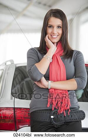 Stock Image - portrait of young woman at car dealer. Fotosearch