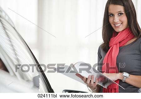 Stock Image - portrait of young woman at car dealer. Fotosearch