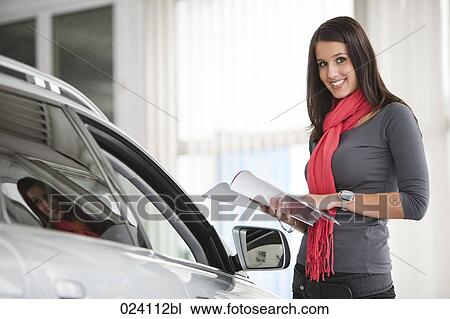 Stock Image - portrait of young woman at car dealer. Fotosearch