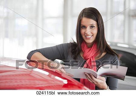Stock Image - portrait of young woman at car dealer. Fotosearch