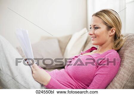 Stock Image - portrait of young woman at home reading letter. Fotosearch