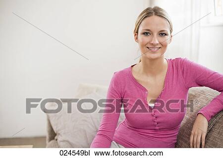 portrait of young woman at home sitting on sofa View Large Photo Image Stock Image - portrait of young woman at home sitting on sofa. Fotosearch