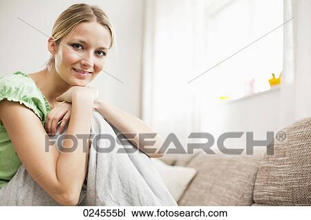 portrait of young woman at home sitting on sofa View Large Photo Image Stock Image - portrait of young woman at home sitting on sofa. Fotosearch
