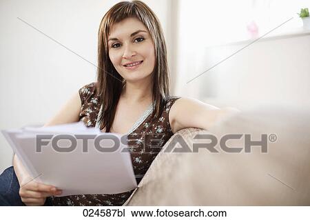 Stock Image - portrait of young woman at home with letter. Fotosearch