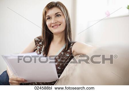 Stock Image - portrait of young woman at home with letter. Fotosearch