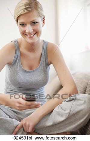 Stock Image - portrait of young woman at home with mobile phone. Fotosearch