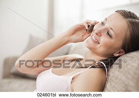 Stock Image - portrait of young woman at home with mobile phone. Fotosearch