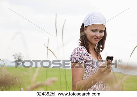 portrait of young woman checking moile phone for text messages View Large Photo Image Stock Image - portrait of young woman checking moile phone for text messages. Fotosearch