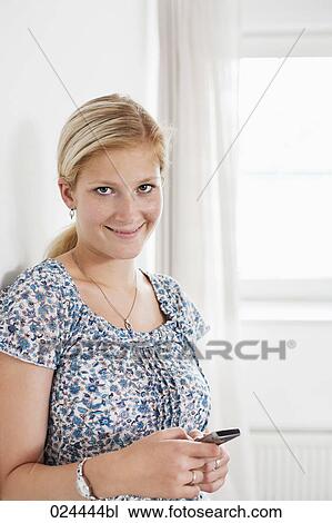portrait of young woman in empty room with mobile phone View Large Photo Image Stock Image - portrait of young woman in empty room with mobile phone. Fotosearch