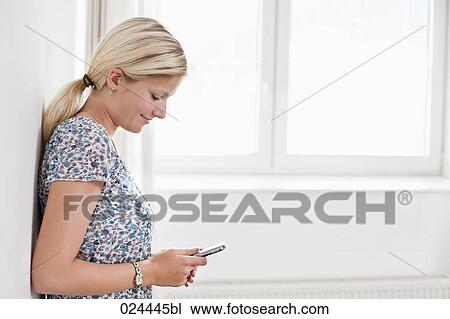 portrait of young woman in empty room with mobile phone View Large Photo Image Stock Image - portrait of young woman in empty room with mobile phone. Fotosearch