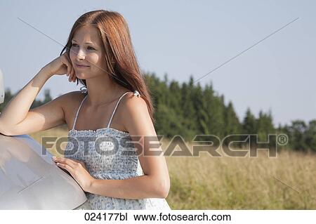 portrait of young woman in summer leaning against car View Large Photo Image Stock Image - portrait of young woman in summer leaning against car. Fotosearch