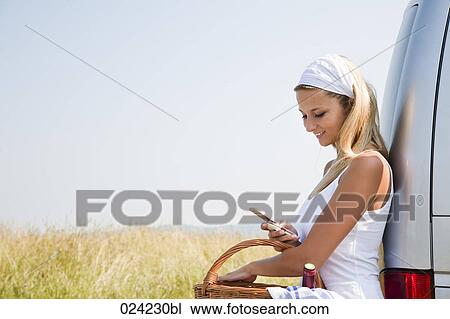 Stock Image - portrait of young woman looking at her mobile phone. Fotosearch