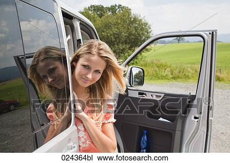Stock Image - portrait of young woman looking out of car. Fotosearch