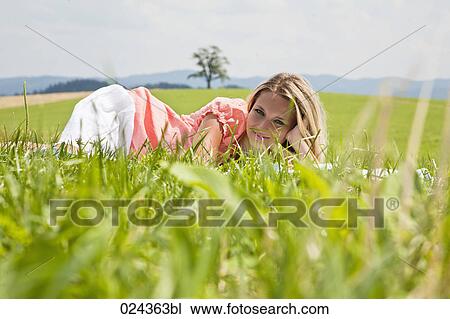 portrait of young woman lying in grass View Large Photo Image Stock Image - portrait of young woman lying in grass. Fotosearch