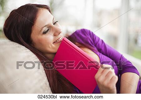 portrait of young woman lying on sofa reading book View Large Photo Image Stock Image - portrait of young woman lying on sofa reading book. Fotosearch