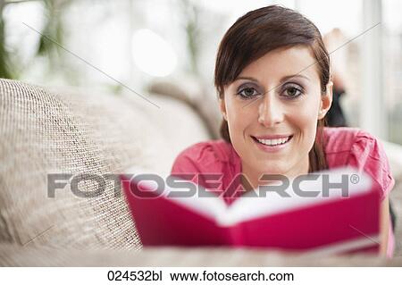 portrait of young woman lying on sofa reading book View Large Photo Image Stock Image - portrait of young woman lying on sofa reading book. Fotosearch