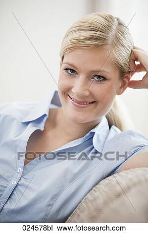 Stock Image - portrait of young woman on sofa. Fotosearch