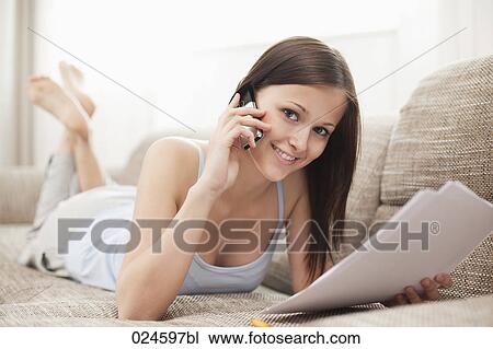 portrait of young woman on sofa talking on mobile phone View Large Photo Image Stock Image - portrait of young woman on sofa talking on mobile phone. Fotosearch