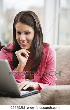 portrait of young woman on sofa working with laptop computer View Large Photo Image Stock Image - portrait of young woman on sofa working with laptop computer. Fotosearch