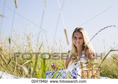 portrait of young woman sitting in meadow having picnic View Large Photo Image Stock Image - portrait of young woman sitting in meadow having picnic. Fotosearch