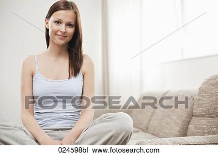 portrait of young woman sitting on sofa View Large Photo Image Stock Image - portrait of young woman sitting on sofa. Fotosearch