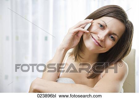 Stock Image - portrait of young woman talking on mobile phone. Fotosearch