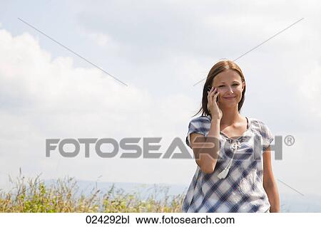 Stock Image - portrait of young woman talking on mobile phone. Fotosearch