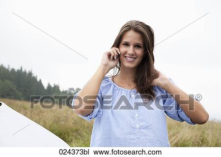 Stock Image - portrait of young woman talking on mobile phone. Fotosearch