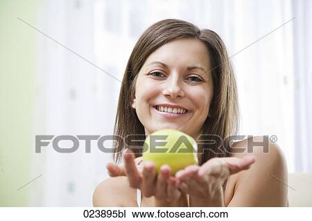 Stock Image - portrait of young woman with apple. Fotosearch