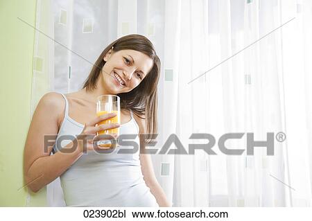 Stock Image - portrait of young woman with glass of juice. Fotosearch