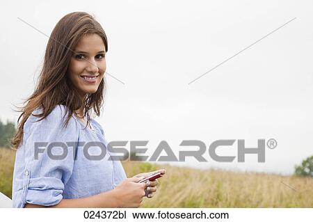Stock Image - portrait of young woman with mobile phone. Fotosearch