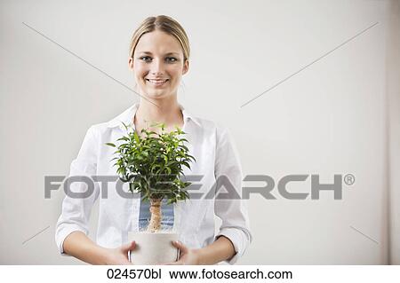 portrait of young woman with potted plant View Large Photo Image Stock Image - portrait of young woman with potted plant. Fotosearch