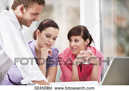 Stock Image - three business people having discussion. Fotosearch