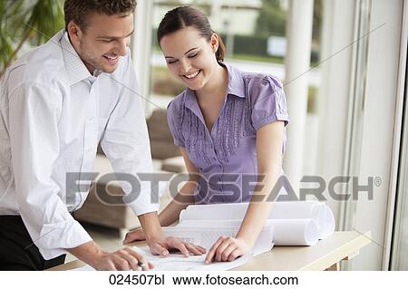 two business people at table looking at blueprint View Large Photo Image Stock Image - two business people at table looking at blueprint. Fotosearch