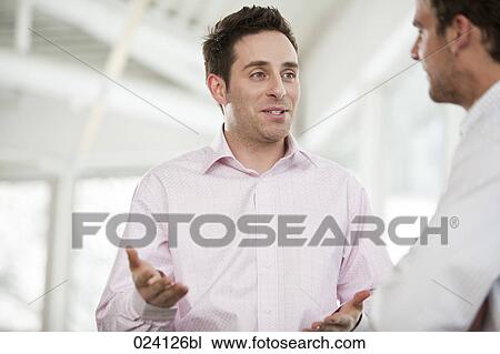 Stock Image - two businessmen having discussion. Fotosearch