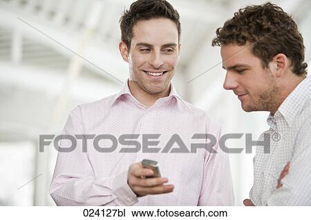 young budsinessman showing text message on mobile phone to colleague View Large Photo Image Stock Image - young budsinessman showing text message on mobile phone to colleague. Fotosearch