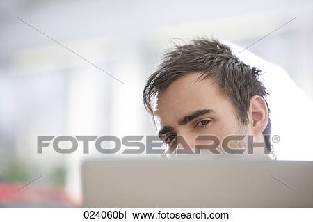 Stock Image - young businessman behind computer. Fotosearch
