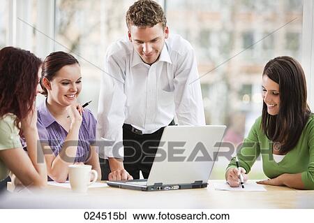 Stock Image - young businessman giving presentation to female colleagues. Fotosearch