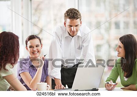 Stock Image - young businessman giving presentation to female colleagues. Fotosearch