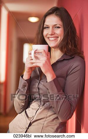 Stock Image - young businesswoman having break drinking coffee. Fotosearch